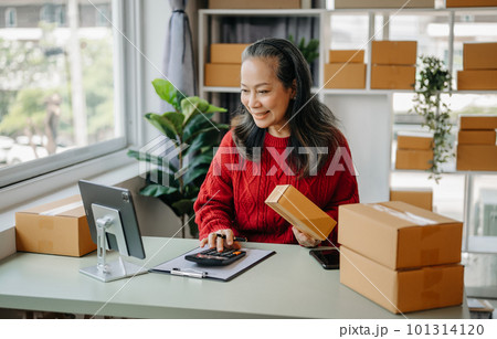 Senior business owner woman prepare parcel box and standing check online orders for deliver to customer on tablet, laptop Shopping Online concept. at home office. Senior business owner woman prepare parcel box and standing check online orders for deliver to customer on tablet, laptop Shopping Online concept. at home office. 101314120