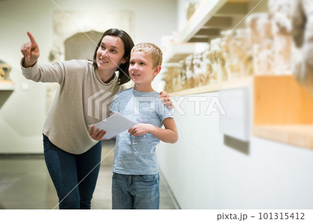 Woman and boy observing sculptures exhibition 101315412