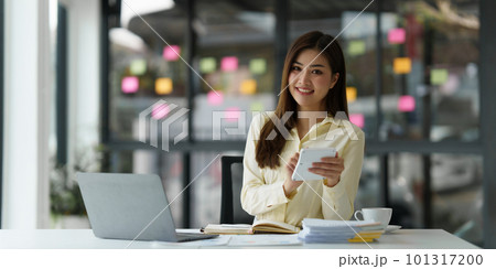 Beautiful Asian Banker or Accountant makes financial report and tax, analyzes profits. Accountant checks status of financial 101317200