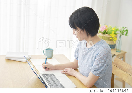 自宅でノートパソコンを使って勉強する女性 自宅でノートパソコンを使って勉強する女性 101318842