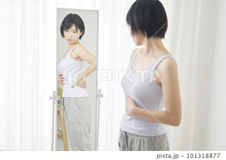 鏡の前でダイエットに悩む女性 101318877