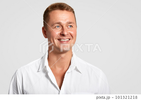 Dremy blue eyed male with positive expression, broad smile, shows white teeth, looks into distance, thinks about something, wears elegant shirt, isolated over white background with blank space Dremy blue eyed male with positive expression, broad smile, shows white teeth, looks into distance, thinks about something, wears elegant shirt, isolated over white background with blank space 101321218