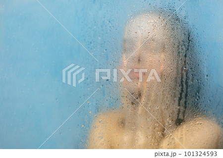 Restful female model with perfect body poses in shower cabine with blurred background, has natural fresh soft skin after taking shower, poses with wet nude body, feels relaxation and relief. 101324593