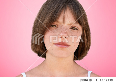 Close up portrait of freckled stylish small kid looks with narrow dark eyes directly into camera, has serious expression, isolated over pink studio background. Children, beauty, lifestyle concept Close up portrait of freckled stylish small kid looks with narrow dark eyes directly into camera, has serious expression, isolated over pink studio background. Children, beauty, lifestyle concept 101325346