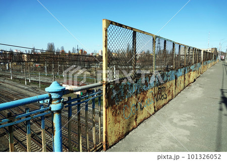 Kiev, Ukraine March 18, 2020: old and rusty bridge over the railway tracks in the city of Kiev Kiev, Ukraine March 18, 2020: old and rusty bridge over the railway tracks in the city of Kiev 101326052