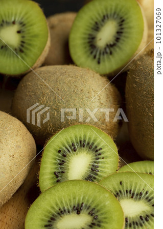 A group of cut green kiwi fruits with black seeds 101327069