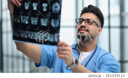 Confident doctor with x-ray picture in office 101329112