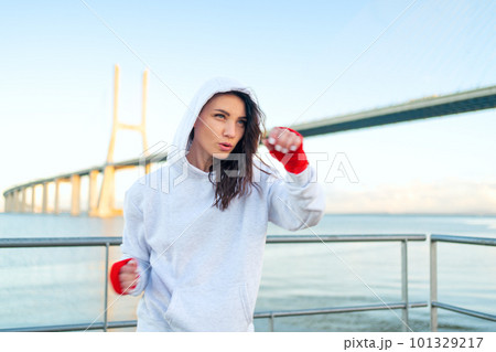 Woman boxing outdoors blue sky background. 101329217