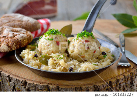 Delicious South Tyrolean bacon dumplings served on sauerkraut in an iron frying pan Delicious South Tyrolean bacon dumplings served on sauerkraut in an iron frying pan 101332227