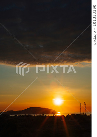 A sunset with a dark cloud in the sky 101333390