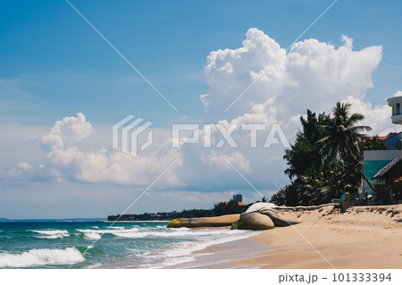 A beach with a boat on it and a cloudy sky in the background 101333394