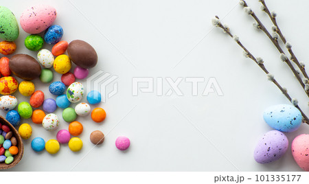 Colorful and chocolate easter eggs with sweet dragee on white background 101335177