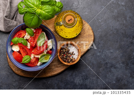 Caprese salad with ripe tomatoes, mozzarella cheese and garden basil Caprese salad with ripe tomatoes, mozzarella cheese and garden basil 101335435