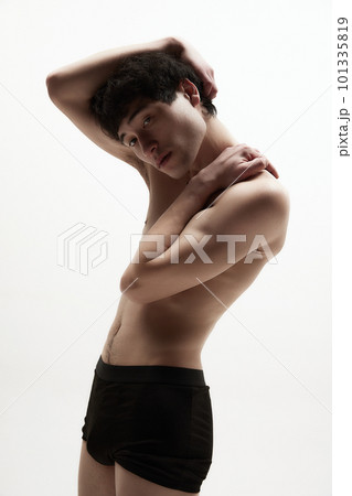 Strong, muscled, relief hands. Young guy posing shirtless in underwear, showing fit strong body against white studio background 101335819