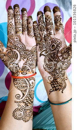 Beautiful artwork drawn on the hand of an Indian bride with herbal heena in wet condition. 101336826