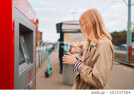 Young pretty blonde woman buying a ticket to the subway train using an electronic terminal 101337564