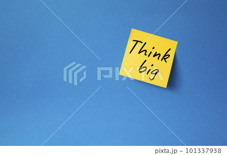 Think big symbol. Orange steaky note with words Think big. Beautiful blue background. Business and Think big concept. Copy space. 101337938