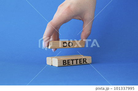 Do better symbol. Wooden blocks with words Do better. Beautiful blue background. Businessman hand. Business and Do better concept. Copy space. 101337995