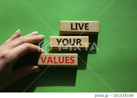 Live your values symbol. Concept words Live your values on wooden blocks. Beautiful green background. Businessman hand. Business and Live your values concept. Copy space. 101338106