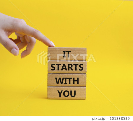 It starts with you symbol. Wooden blocks with words It starts with you. Beautiful yellow background. Businessman hand. Business and It starts with you concept. Copy space. 101338539