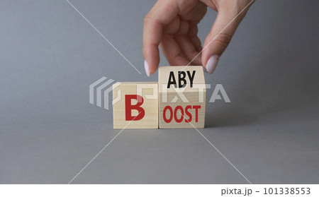 Baby boost symbol. Businessman hand Turnes cube and changes word Boost to Baby. Beautiful grey background. Business and baby boost concept. Copy space 101338553