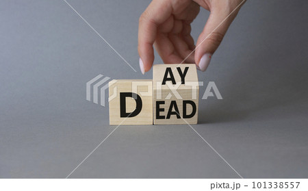 Day of the Dead symbol. Businessman hand turns wooden cubes and changes word Dead to Day. Beautiful grey background. Day of the Dead concept. Copy space. 101338557