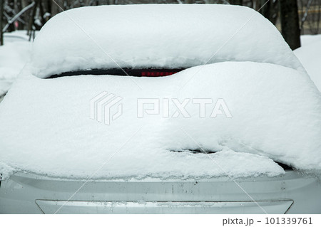 rear window with windshield wiper, washer and brake light covered with a large layer of snow on a winter cold day. rear window with windshield wiper, washer and brake light covered with a large layer of snow on a winter cold day. 101339761