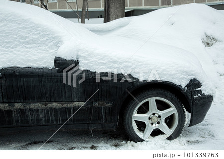 dirty black car side view, covered with snow passenger transport on a cold winter day on a city street, nobody. dirty black car side view, covered with snow passenger transport on a cold winter day on a city street, nobody. 101339763