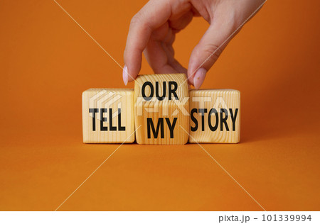 Tell our or my story symbol. Businessman hand turns wooden cubes and changes the words Tell my story to tell our story. Beautiful orange background. Business concept. Copy space 101339994