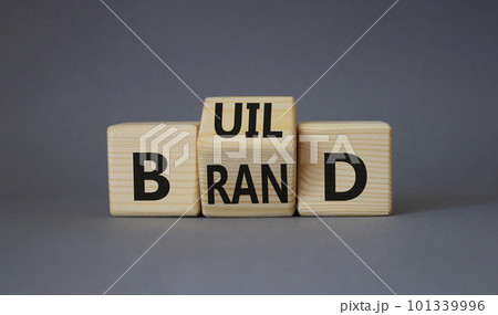 Build your brand symbol. Turned wooden cubes with words Build and Brand. Beautiful grey background. Build your brand and business concept. Copy space 101339996