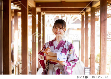 老舗旅館の渡り廊下を渡る若い女性 老舗旅館の渡り廊下を渡る若い女性 101342978