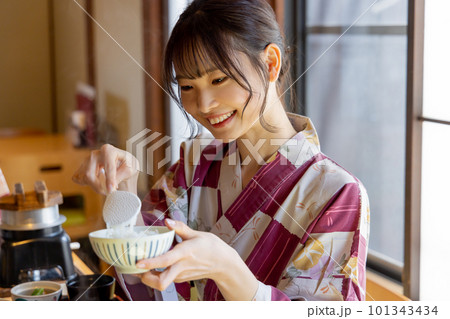 旅館で料理を楽しむ若い女性　ご飯をよそう　よそる 101343434