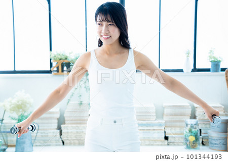ダンベルでトレーニングする若い女性 ダンベルでトレーニングする若い女性 101344193