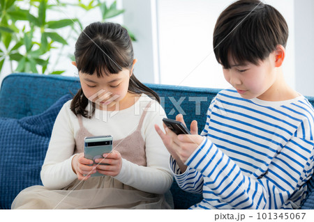 リビングでスマホを見る子供 101345067