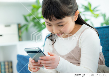 リビングでスマホを見る子供 101345070