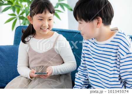 リビングでスマホを見る子供 101345074