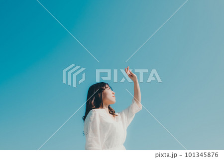 青空バックに手をかざす女性 101345876
