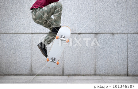 Asian woman skateboarder skateboarding in modern city Asian woman skateboarder skateboarding in modern city 101346587