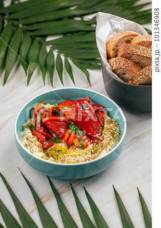 Portion of hummus bowl with baked pepper 101346908