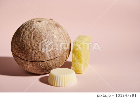 Still life. Coconut and organic bar of soap, solid dry shampoo and conditioner with natural ingredients and essential oils for healthy shiny hair, isolated on pink. Organic cosmetic products concept 101347391