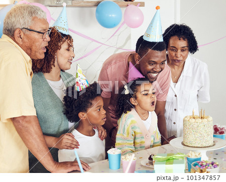 Birthday, cake and a girl blowing out candles while celebrating with her black family in their home. Kids, party or celebration with parents, grandparents and children bonding together in a house Birthday, cake and a girl blowing out candles while celebrating with her black family in their home. Kids, party or celebration with parents, grandparents and children bonding together in a house 101347857