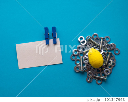 Easter egg on blue background with metal screws Easter egg on blue background with metal screws 101347968