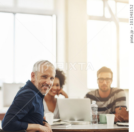 I lead the best team in the biz. a group of coworkers having a meeting in an office. 101348152