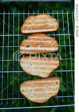 Grilled crispy toast on the wire rack. Outdoor recreation. Bonfire, grill, delicious. View from above. Grilled crispy toast on the wire rack. Outdoor recreation. Bonfire, grill, delicious. View from above. 101350488