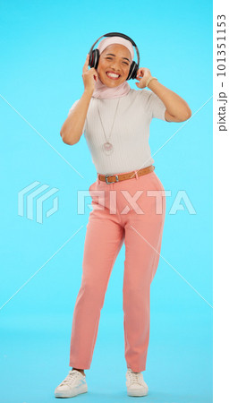 Headphones, dance and Muslim woman in studio on blue background listening to music, song and audio. Dancing, party mockup and isolated female on chromakey streaming radio for peace, relax and happy 101351153