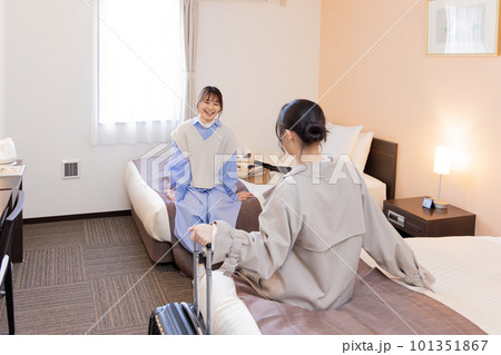 チェックイン後、部屋でベッドに座る若い女性 チェックイン後、部屋でベッドに座る若い女性 101351867
