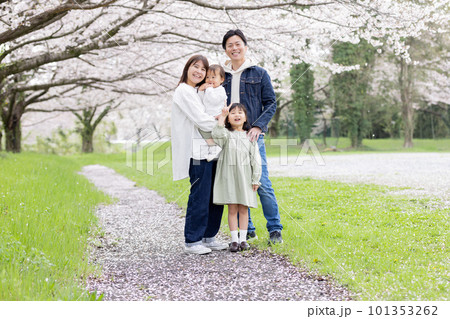 桜の咲く公園を歩く家族 101353262