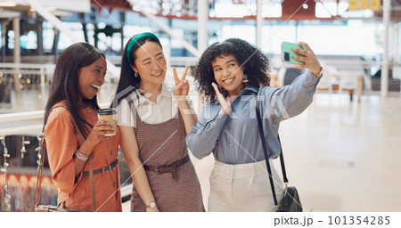 Selfie, friends and social media with woman together posing for a photograph in a mall or shopping center. Phone, social media and smile with a happy female friend group taking a picture for fun 101354285