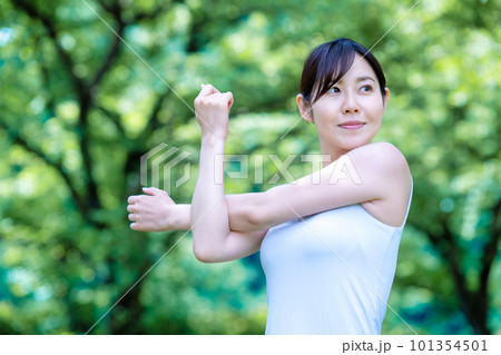 新緑の中でストレッチをする女性 101354501