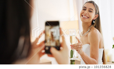Smartphone photography of bride with champagne glass for wedding celebration to post on social media app. Smile portrait photos or picture taken of woman on digital cellphone and celebrate with wine 101356828